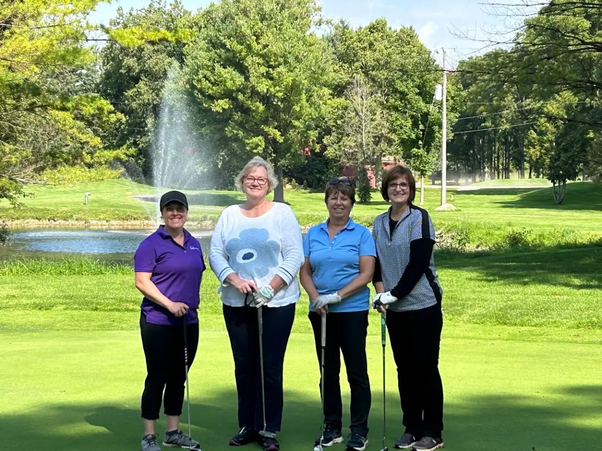 a group of people standing on top of a grass covered field